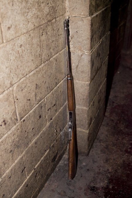 Rifle propped against wall of slaughter room