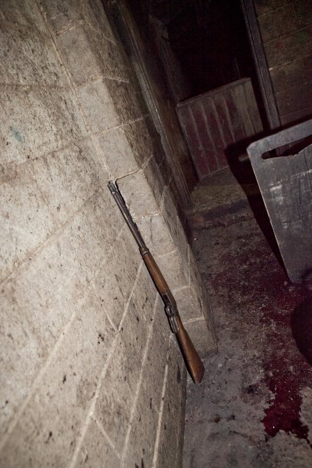 Rifle propped up against wall of slaughter room