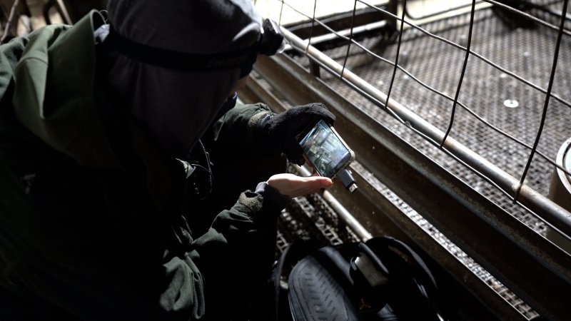 An investigator looks through footage from hidden cameras on a phone